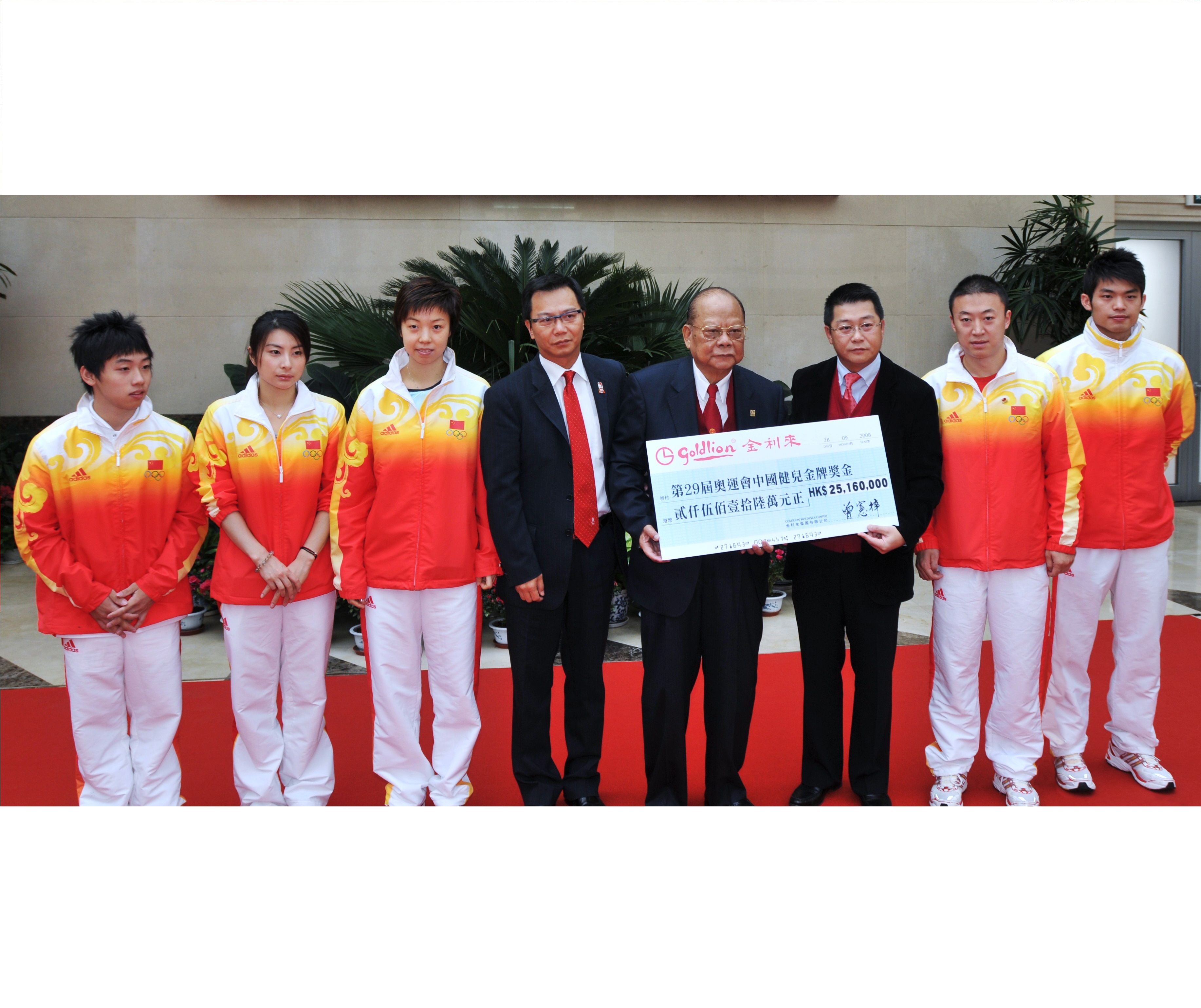 2008年曾宪梓、曾智明（右三）、曾智雄(左四)向北京奥运金牌运动员代表邹凯、郭晶晶、张怡宁、马琳、林丹转交奖金支票