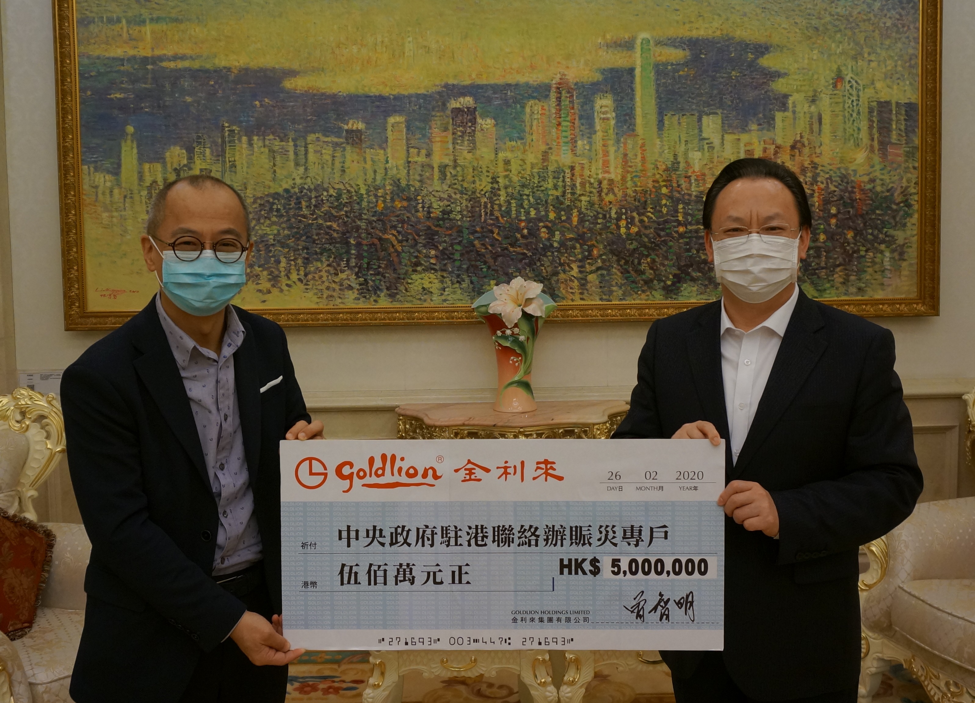 曾智谋(左)代表曾智明向中联办副主任谭铁牛(右)递交支持内地抗疫捐款港币500万元
